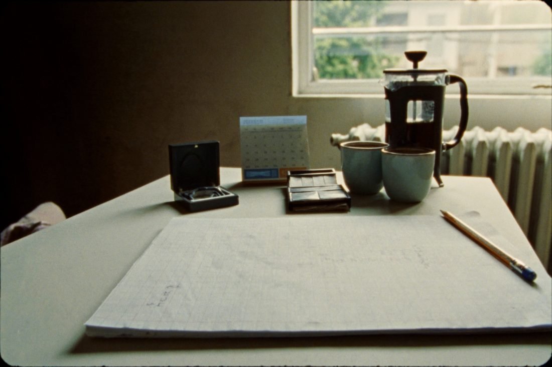 A new notebook and a sharpened pencil beside an open ring box and a desk calendar