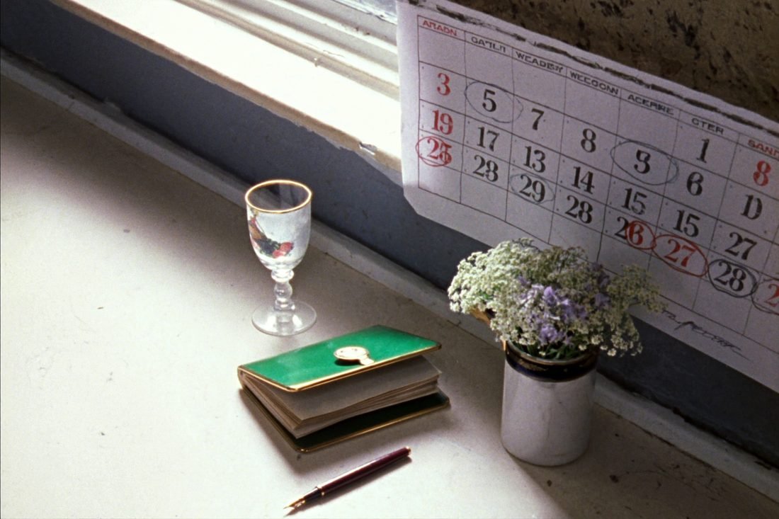 A paper wall calendar and a desk diary with dates circled in pencil